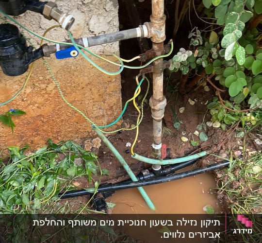 צינורות מים וברזים ליד שלולית בוץ